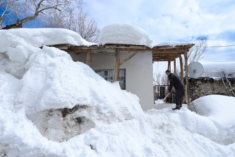 Tek katlı ev ve ahırların karla kaplandığı merkeze bağlı Durankaya beldesindeki yaklaşık 2 bin rakımlı Yeni Mahalle'de yaşayanlar, ilkbaharda da ev ve ahırlar ile ot yığınlarının üzerinde biriken karı temizleyip, hayvanlarının bakımını kar örtüsünün üzerinde yapmayı sürdürüyor.