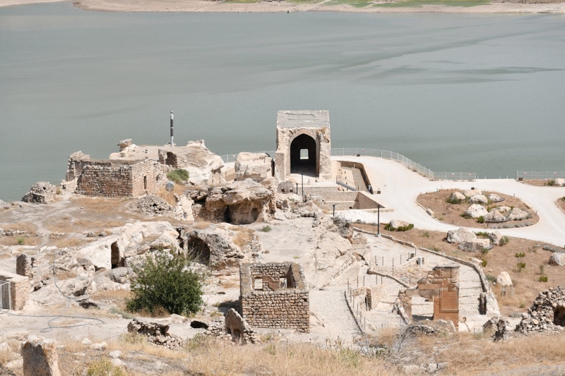 <p><b>HASANKEYF KALESİ VE BÜYÜK SARAY</b></p><p><b><br></b></p><p>2025 yılındaki kazı çalışmalarında Hasankeyf Kalesi bölgesinde bulunan Büyük Saray ve çevresine ağırlık verildi. </p><p>Büyük Saray Hasankeyf Kalesi'nin ana yapısı ve Büyük Saray'ın ilk ne zaman ve kim tarafından yapıldığına dair net bilgi yok. </p><p><br></p><p>Mardin Artuklu Üniversitesi (MAÜ) Edebiyat Fakültesi Sanat Tarihi Bölümü Öğretim Üyesi Doç. Dr. Zekai Erdal, geçen yıl AA'ya yaptığı açıklamada "Büyük Saray'ın üzerindeki taşlı işaretlerin Hasankeyf Köprüsü üzerindeki taşlı işaretlerle benzerliği münasebetiyle yapının Roma dönemindeki askeri garnizonun bir parçası olarak inşa edildiği, daha sonra bölgeye egemen olan Artuklular döneminde saray olarak değerlendirildiği kaynaklarda geçiyor" demişti. </p><p><br></p><p>Büyük Saray bilinmeyen bir dönemde kullanılmaz hale geldikten sonra içerisi toprak ve molozlarla dolmuş, üzerine ise mezarlık yapılmış. </p>